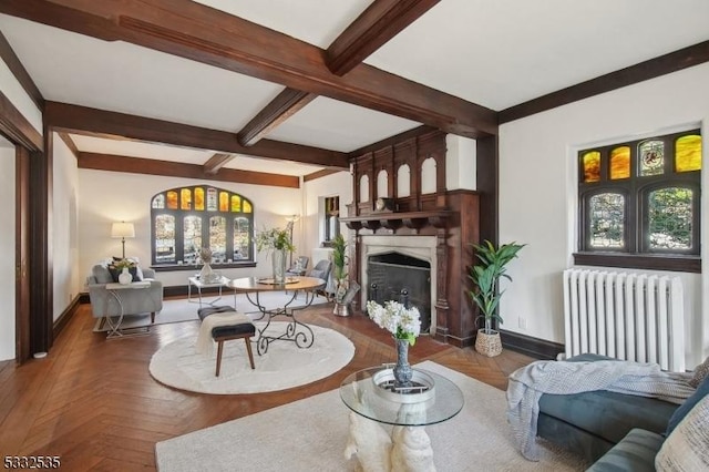 living room featuring radiator, parquet floors, and beam ceiling