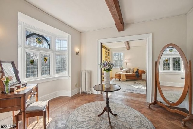 sitting room with radiator, beam ceiling, and parquet floors