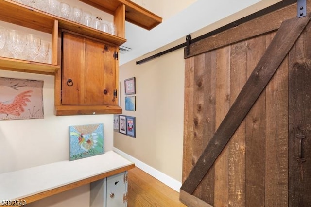 corridor featuring a barn door and hardwood / wood-style flooring