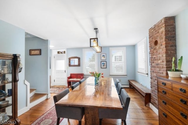 dining room with light hardwood / wood-style floors and a baseboard heating unit