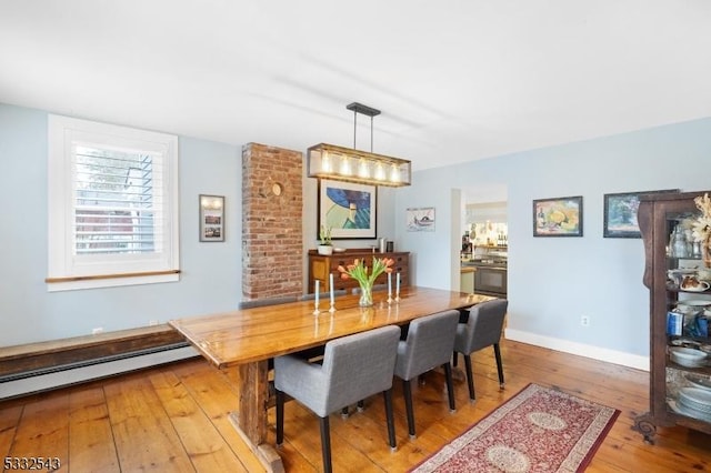 dining room with light wood-type flooring and baseboard heating