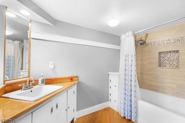 bathroom with hardwood / wood-style floors, vanity, and shower / tub combo