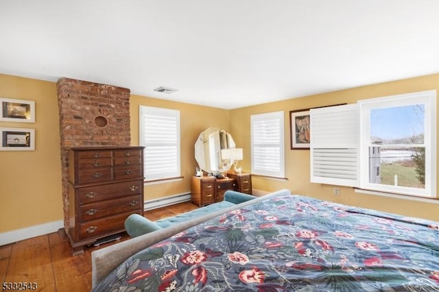 bedroom featuring hardwood / wood-style floors and baseboard heating