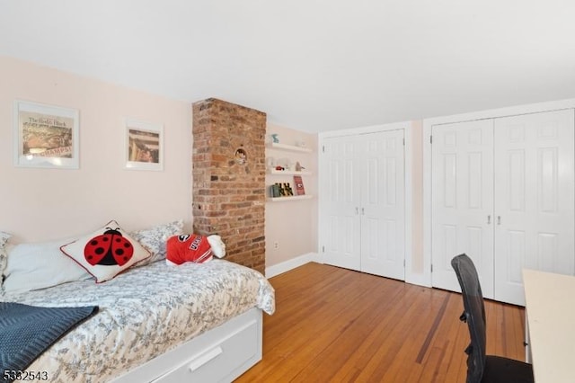 bedroom featuring light hardwood / wood-style floors and multiple closets