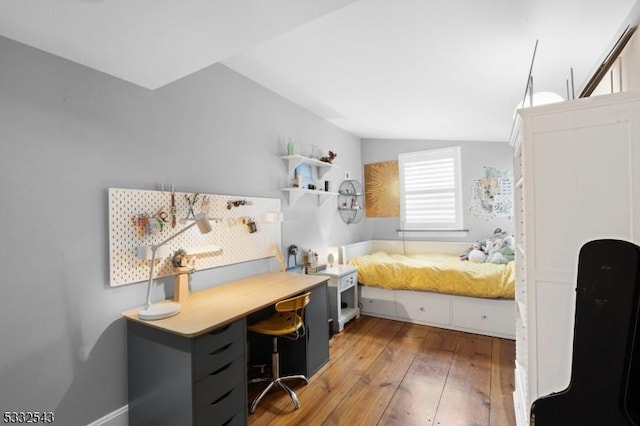 bedroom with hardwood / wood-style floors and lofted ceiling