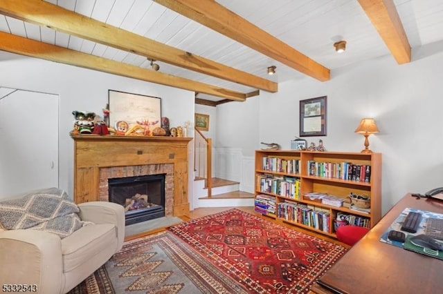 sitting room featuring beam ceiling and a brick fireplace