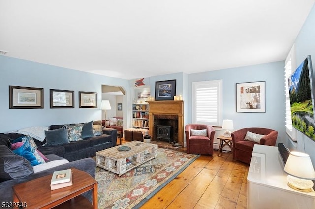 living room featuring a wood stove and light hardwood / wood-style flooring