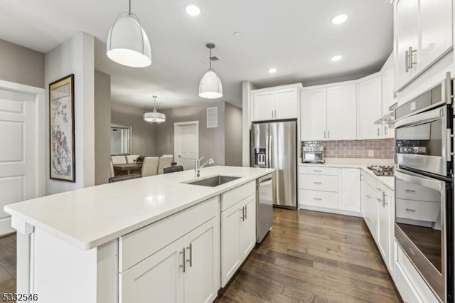 kitchen with sink, white cabinetry, and a center island with sink