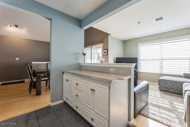 kitchen featuring dark hardwood / wood-style flooring, beamed ceiling, and white cabinets