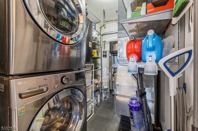 laundry room with gas water heater and stacked washer / dryer