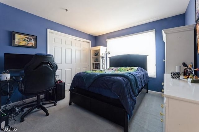 bedroom with light colored carpet and a closet