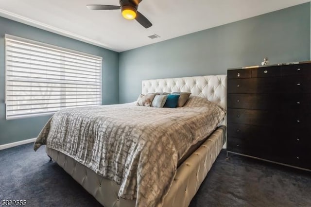 bedroom with multiple windows, ceiling fan, and dark colored carpet