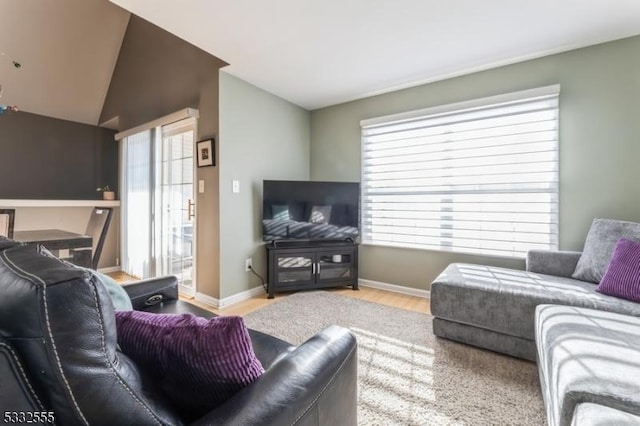 living room featuring lofted ceiling and light hardwood / wood-style flooring