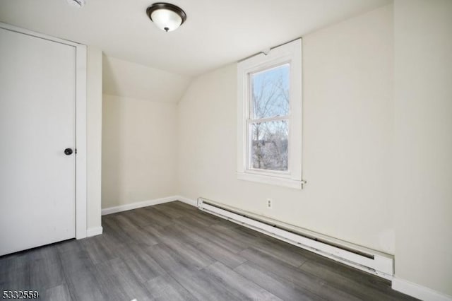 additional living space with lofted ceiling, a baseboard radiator, and dark wood-type flooring