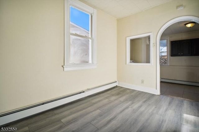 spare room featuring a baseboard radiator and light wood-type flooring