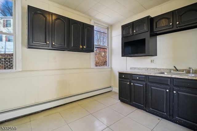 kitchen featuring light tile patterned floors, sink, and a baseboard radiator