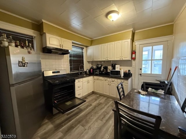 kitchen with sink, stainless steel appliances, light hardwood / wood-style flooring, and white cabinetry