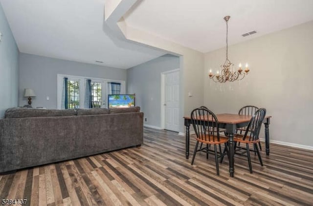 dining room with hardwood / wood-style flooring and a notable chandelier