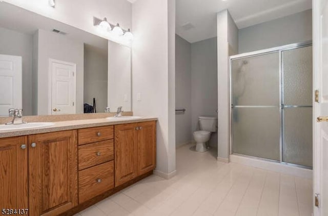 bathroom with toilet, a shower with door, and vanity