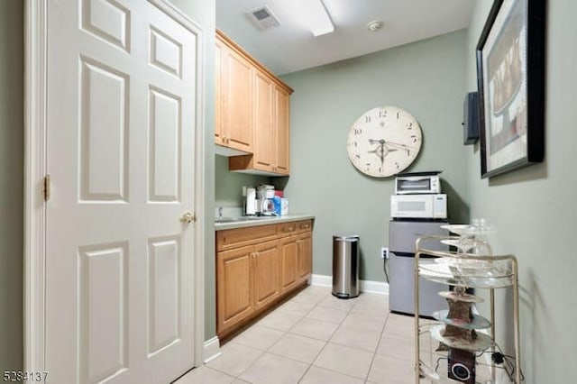 interior space featuring light tile patterned floors and light brown cabinetry