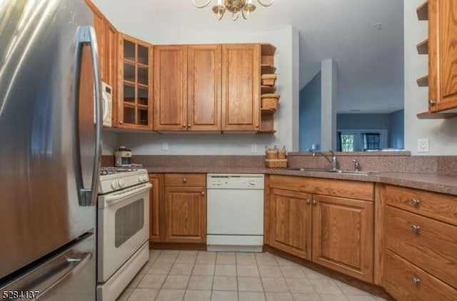 kitchen with light tile patterned floors, sink, white appliances, and a chandelier