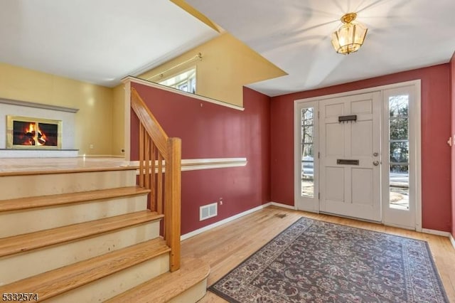 foyer entrance with hardwood / wood-style flooring and a healthy amount of sunlight