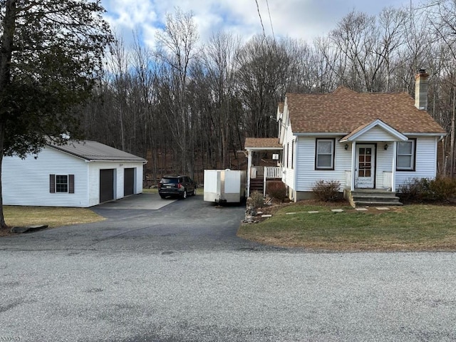 view of front facade with a garage, an outdoor structure, and a front yard