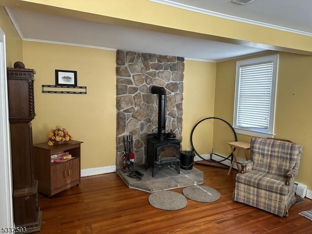 living area featuring a wood stove, dark hardwood / wood-style flooring, and ornamental molding