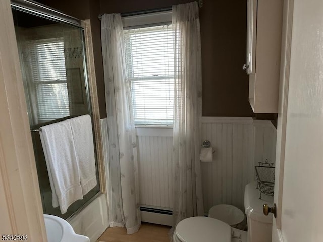 bathroom featuring shower / bathtub combination, toilet, a wealth of natural light, and a baseboard radiator