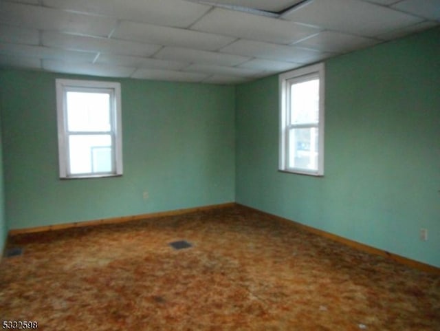 spare room with a drop ceiling and carpet