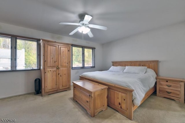 bedroom featuring light carpet and ceiling fan