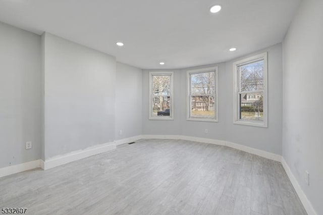 unfurnished room with recessed lighting, baseboards, and light wood-style floors