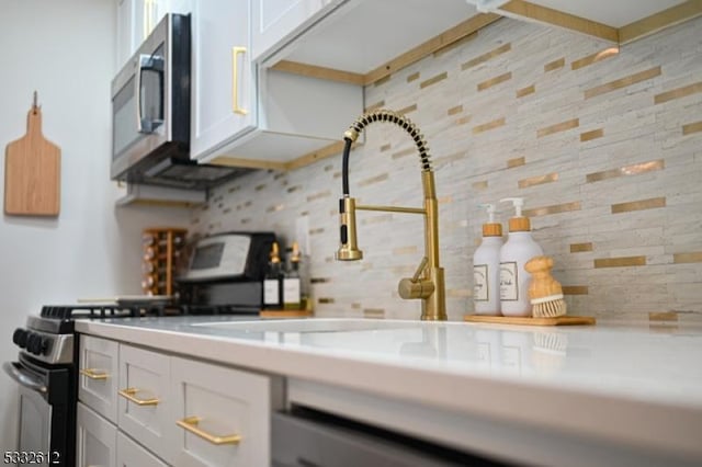 kitchen featuring white cabinets, decorative backsplash, and appliances with stainless steel finishes