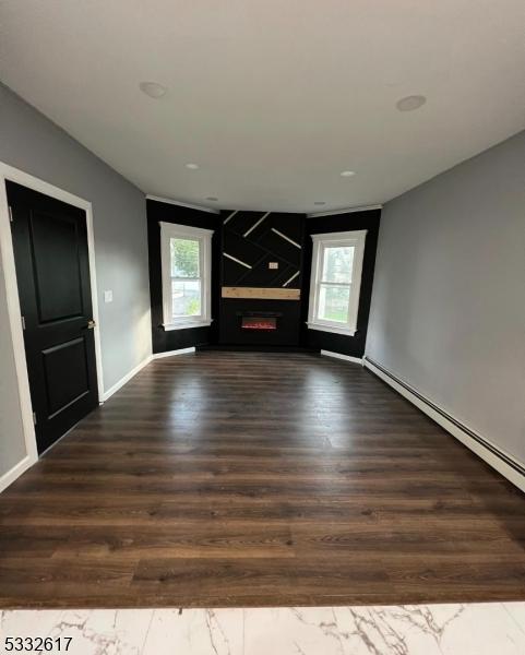 unfurnished living room with a fireplace and dark hardwood / wood-style flooring