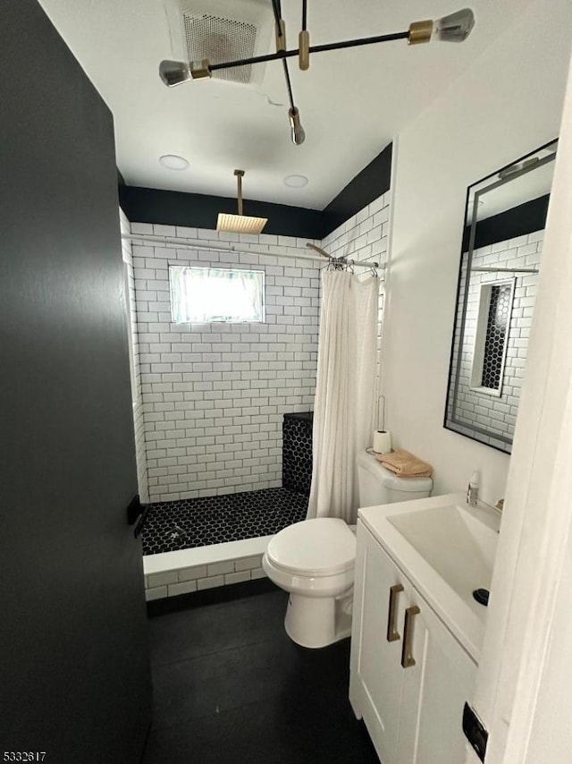 bathroom with curtained shower, vanity, and toilet