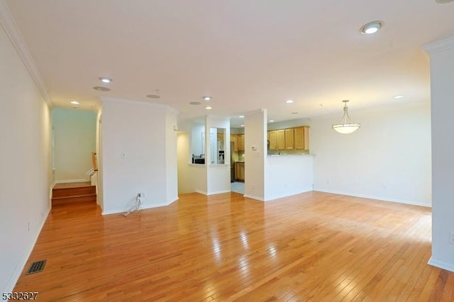 spare room with light hardwood / wood-style floors and crown molding