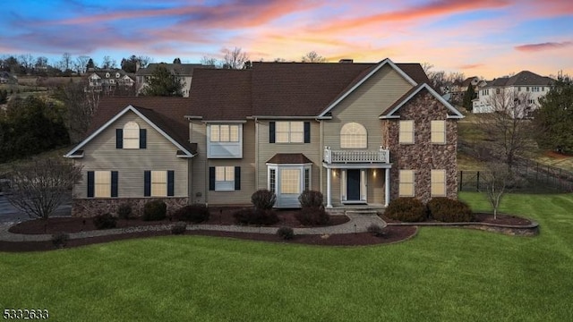 view of front of home featuring a yard and a balcony