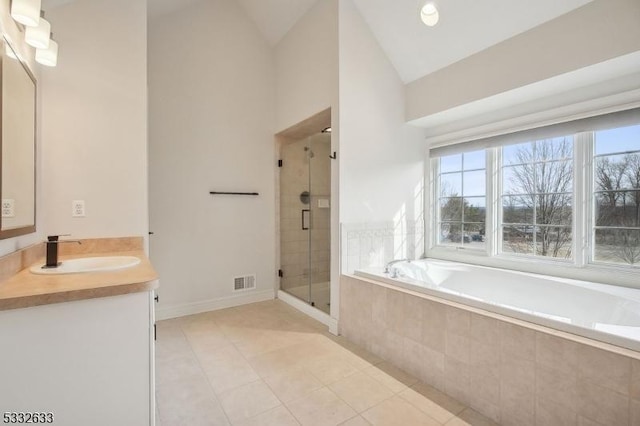 bathroom featuring vanity, tile patterned flooring, vaulted ceiling, and shower with separate bathtub