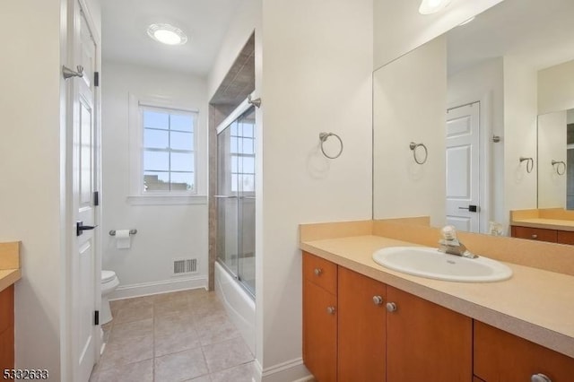 full bathroom featuring vanity, tile patterned floors, enclosed tub / shower combo, and toilet