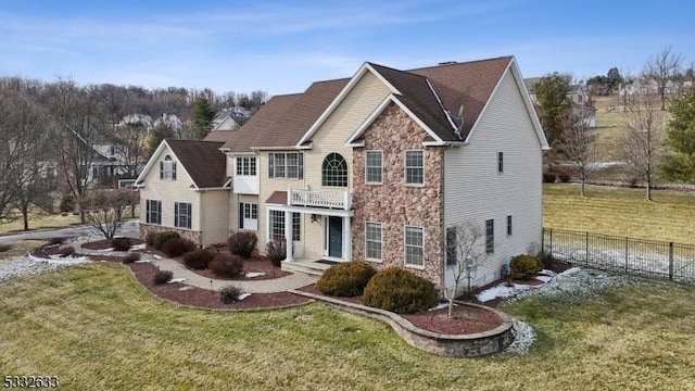 front of property featuring a front yard and a balcony