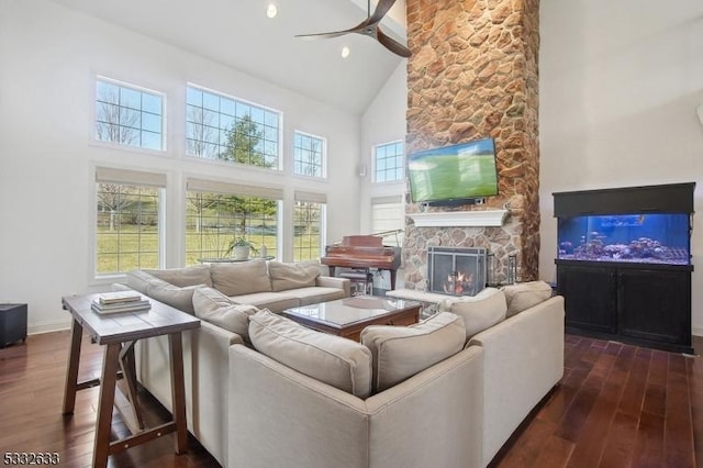 living room featuring dark hardwood / wood-style flooring, ceiling fan, a fireplace, and high vaulted ceiling