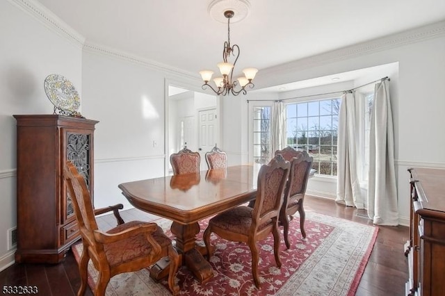 dining room featuring ornamental molding, dark hardwood / wood-style floors, and a chandelier