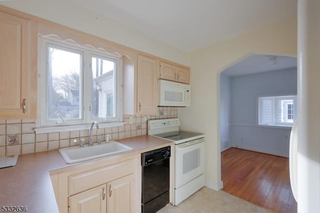 kitchen with white appliances, sink, light wood-type flooring, backsplash, and light brown cabinets