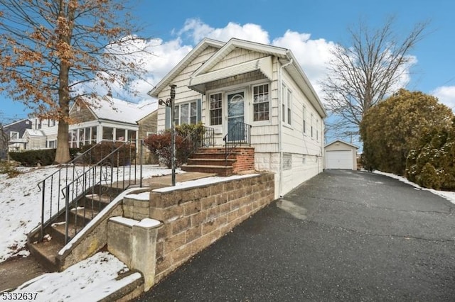 view of front of property featuring a garage and an outdoor structure