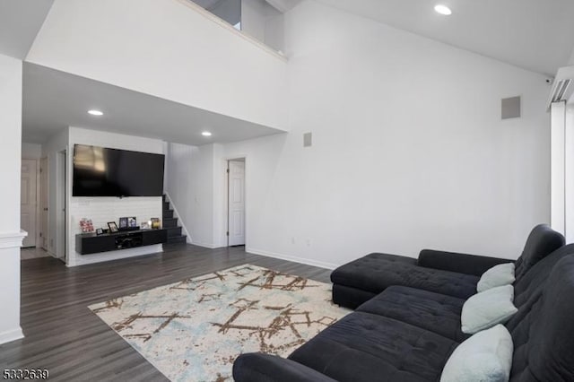 living room with a towering ceiling and dark hardwood / wood-style floors