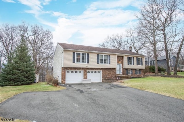 bi-level home featuring a garage and a front lawn