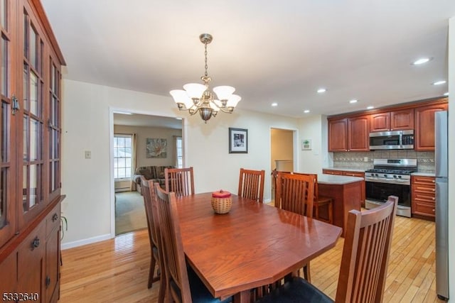 dining space featuring light wood-type flooring and a notable chandelier