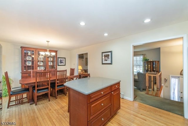 kitchen featuring a chandelier, light hardwood / wood-style flooring, a kitchen island, and hanging light fixtures