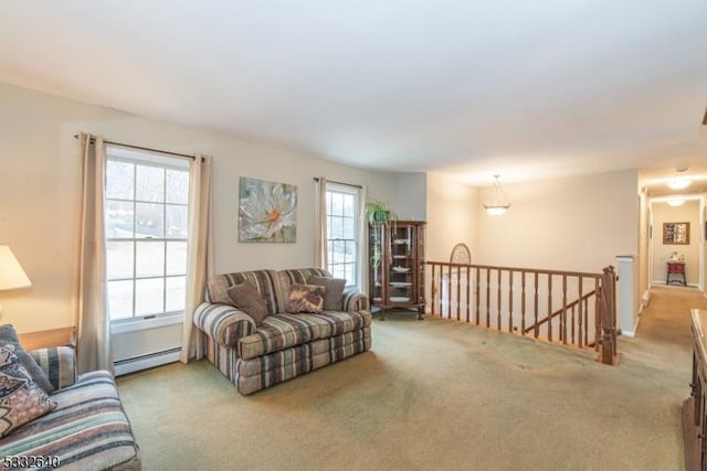 living room with a healthy amount of sunlight, light colored carpet, and a baseboard heating unit