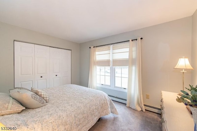 bedroom featuring dark colored carpet, baseboard heating, and a closet